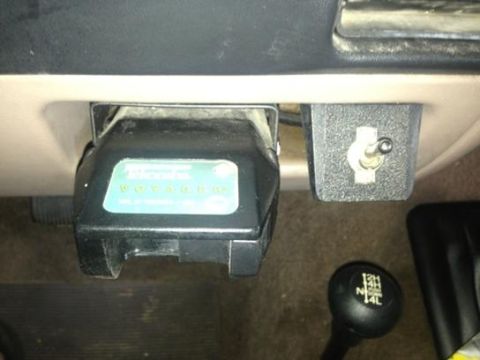 1986 Ford Bronco - Interior view of a trailer brake controller and 4x4 shifter knob.
