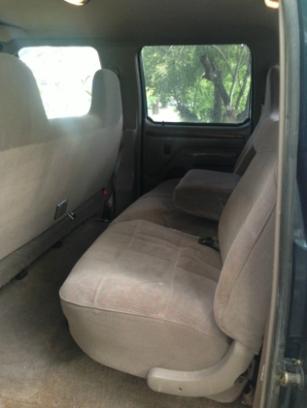 1986 Ford Bronco - The interior of a vehicle is shown, focusing on the rear seating area and a view through the window.