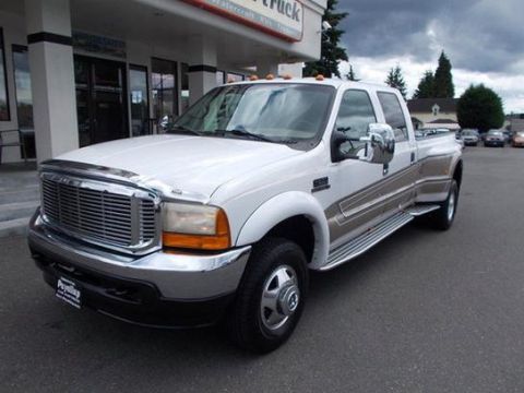 2001 Ford F-350 - This 2001 Ford F-350 dually pickup truck is parked outside a dealership with a cloudy sky overhead.