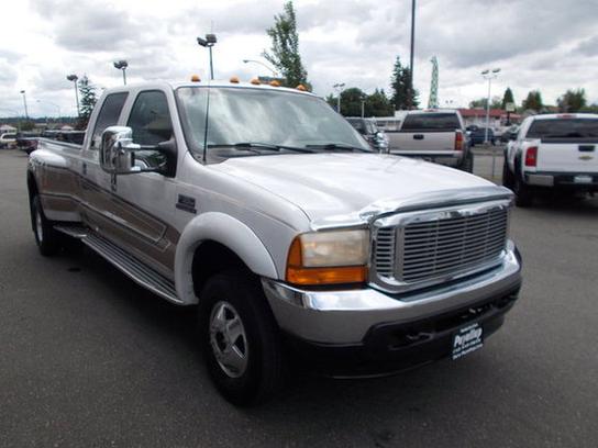White 2001 Ford F-350 Super Duty dually truck, front 3/4 view, chrome grille, chrome bumper, chrome side steps, brown pinstripes