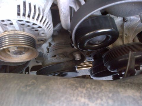 1994 Ford Bronco - Close-up view of engine belt tensioner and pulleys.