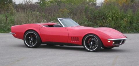 1976 Chevrolet Corvette - Red convertible sports car with custom black wheels and red brake calipers.