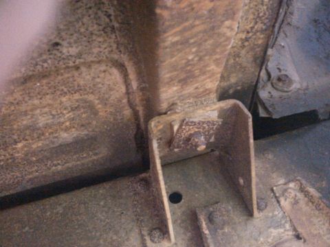 1957 Ford F-100 - Close-up view of heavily rusted metal frame components and brackets.