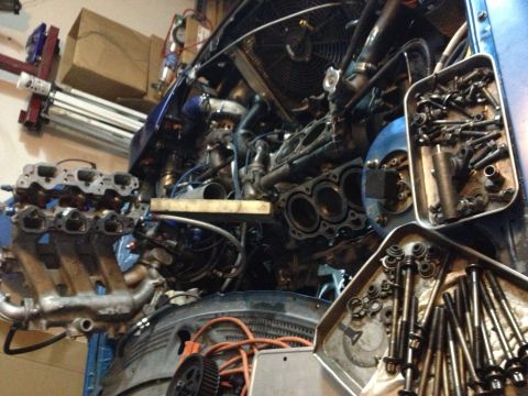 1995 Ford Probe - Engine bay during disassembly, with engine parts and tools laid out. The Supermotors.net logo is visible in the lower right corner.