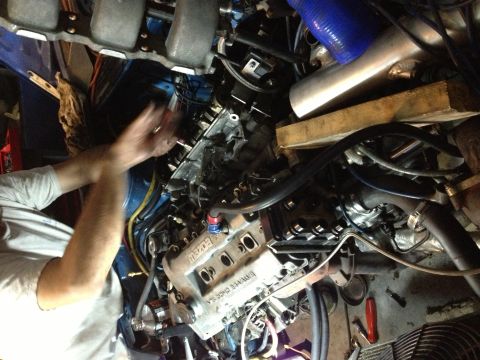 1995 Ford Probe - Hands are working on an engine, with various hoses and parts visible in the engine bay.