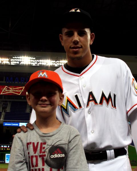 1987 Ford Bronco - A young fan poses for a photo with a Miami Marlins player at a baseball stadium.