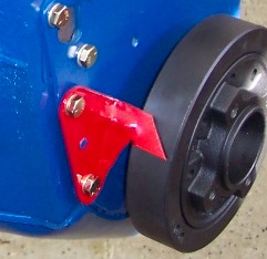 1978 Ford Bronco - A red bracket is attached to a blue component, with a pulley visible to the right.