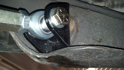 1970 Ford Torino - Close-up view of a vehicle's suspension component, a hex bolt and a spherical bearing.