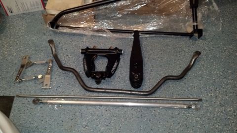 1970 Ford Torino - A collection of aftermarket suspension parts, including sway bars and adjustable links, are displayed on a garage floor.