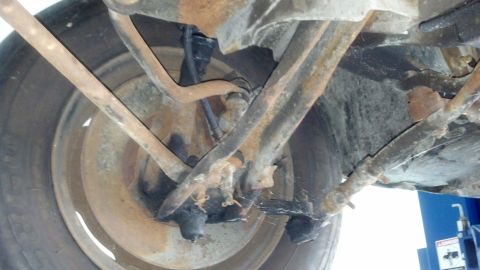 1970 Ford Torino - This photo shows the underside of a vehicle's suspension system, including control arms and a wheel.