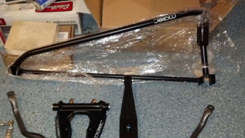 1970 Ford Torino - Automotive suspension parts, including a sway bar and control arm, are laid out on a garage floor.