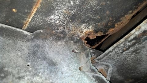 1970 Ford Torino - Close-up view of rusted and damaged vehicle frame components, indicating structural compromise.