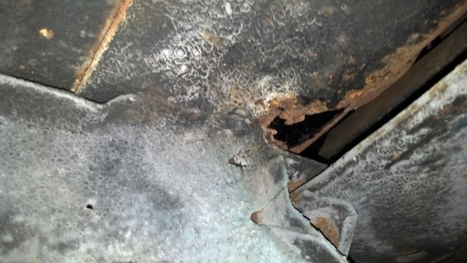 Underside frame damage and rust on a vehicle part