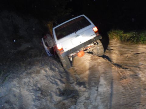 2005 Jeep Wrangler - A white Jeep Cherokee XJ navigates a steep, sandy incline in the dark, with its rear end prominently displayed.