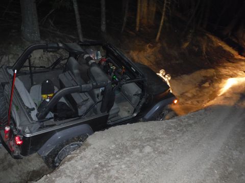 2005 Jeep Wrangler - Jeep Wrangler navigating a steep dirt incline in the dark, with auxiliary lights on.