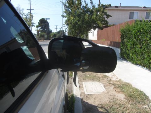 1997 Dodge 3500 - Side mirror assembly of a white vehicle parked outdoors.