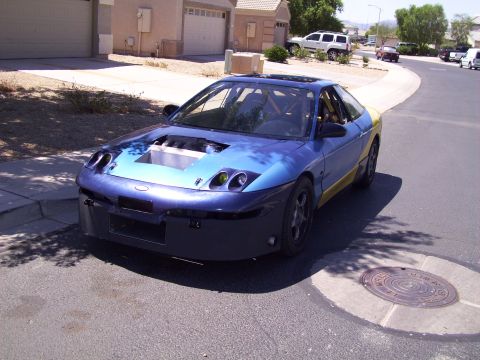1995 Ford Probe - This modified coupe has a custom front bumper and a large opening in the hood revealing the engine.