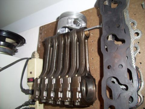1995 Ford Probe - Engine connecting rods and a piston are displayed on a pegboard next to engine gaskets.
