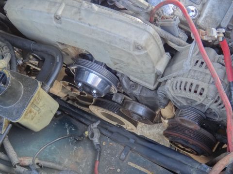 1995 Ford Taurus - Close-up view of an engine bay, focusing on the alternator and various pulleys.