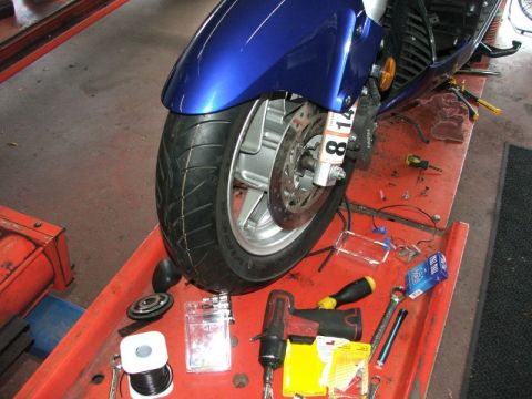 2006 Honda Reflex - Motorcycle front wheel and brake assembly with tools laid out on a service tray.