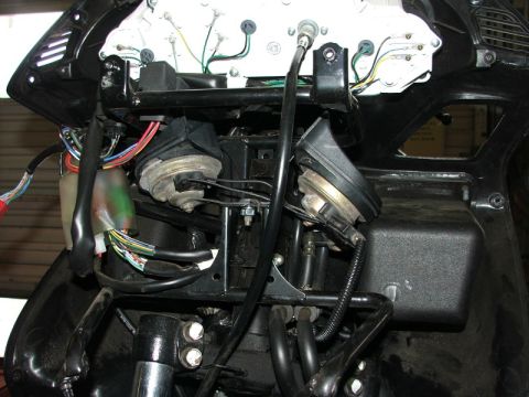 2006 Honda Reflex - The front of a motorcycle is disassembled, revealing its internal wiring and horn components.