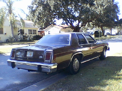 1987 Ford Crown Victoria LTD - This 1987 Ford Crown Victoria LTD is seen from the rear on a sunny day in a neighborhood.