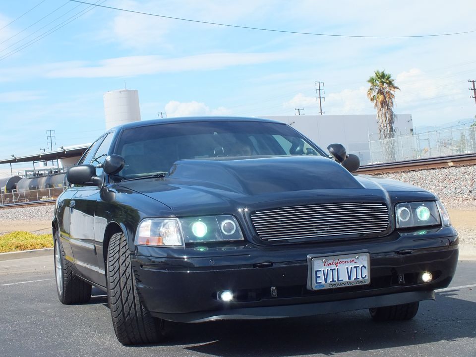 Black sedan front close-up with chrome billet grille and California EVIL VIC plate