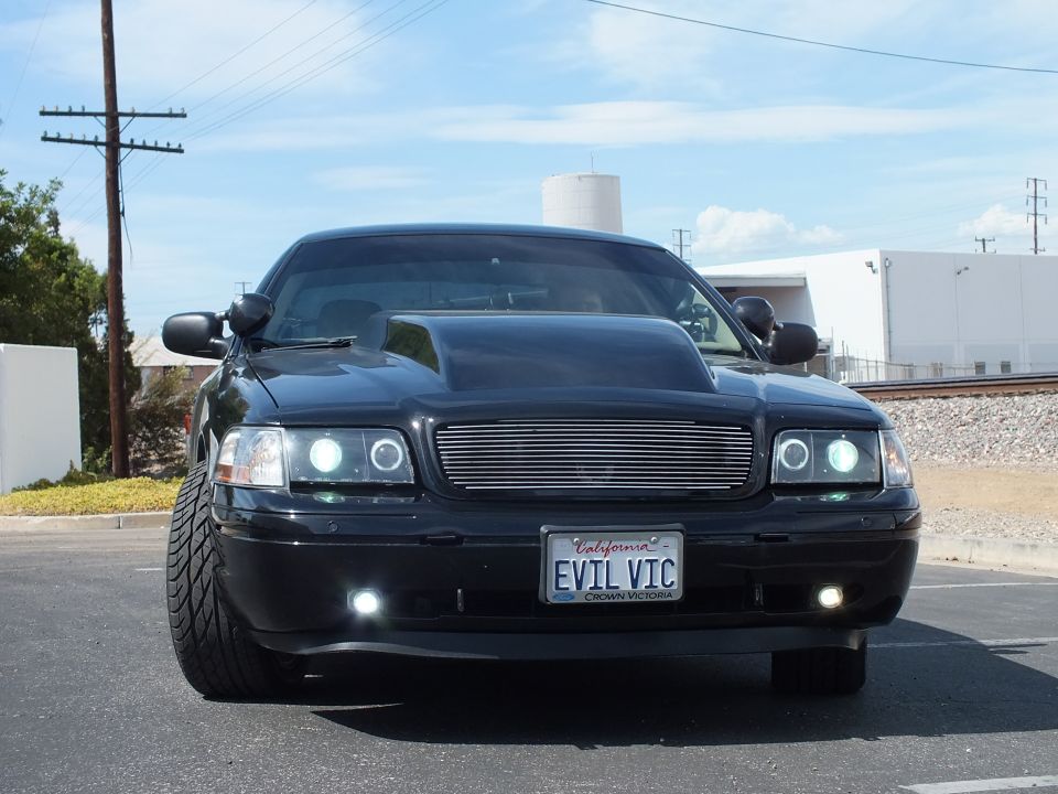 Head-on view of black sedan with billet grille, halo lights and EVIL VIC plate