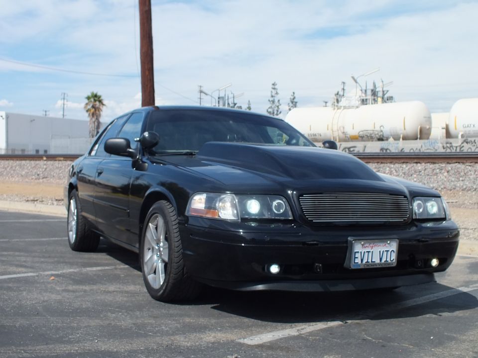 Black sedan front 3/4 in parking lot, billet grille, halo lights, EVIL VIC plate
