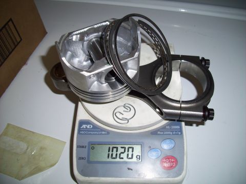 1995 Ford Probe - Weighing a piston and connecting rod assembly on a digital scale.