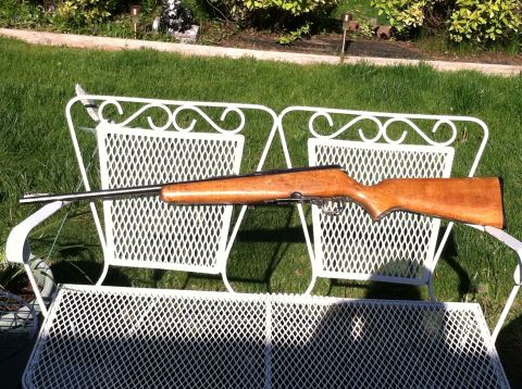 1989 Ford Bronco - A rifle is placed on a white metal bench in a grassy yard.