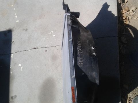 1986 Ford Bronco - A radiator fan shroud is shown on a concrete surface, with text indicating a caution for the fan.
