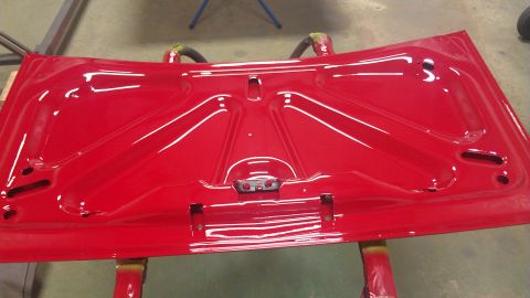1972 Pontiac Trans Am - The underside of a freshly painted red car hood is shown, resting on sawhorses.