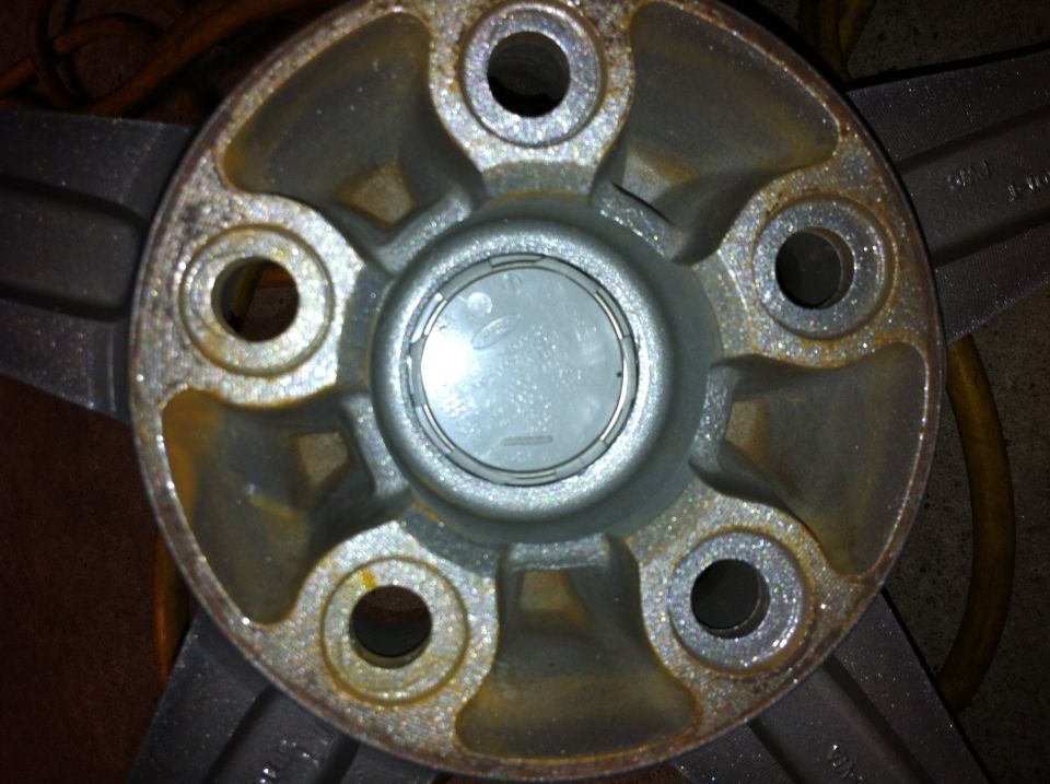 Wheel hub center cap with faint Ford logo