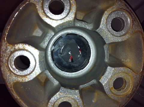 1995 Ford Mustang - This photo shows a close-up view of a vehicle's wheel hub, revealing some rust and a central plastic component.