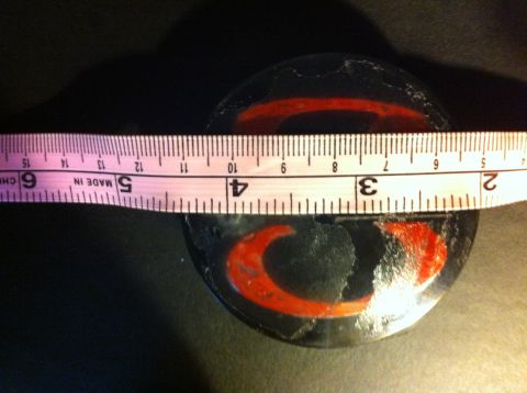 1995 Ford Mustang - A center cap with a red crescent logo is measured with a tape measure.