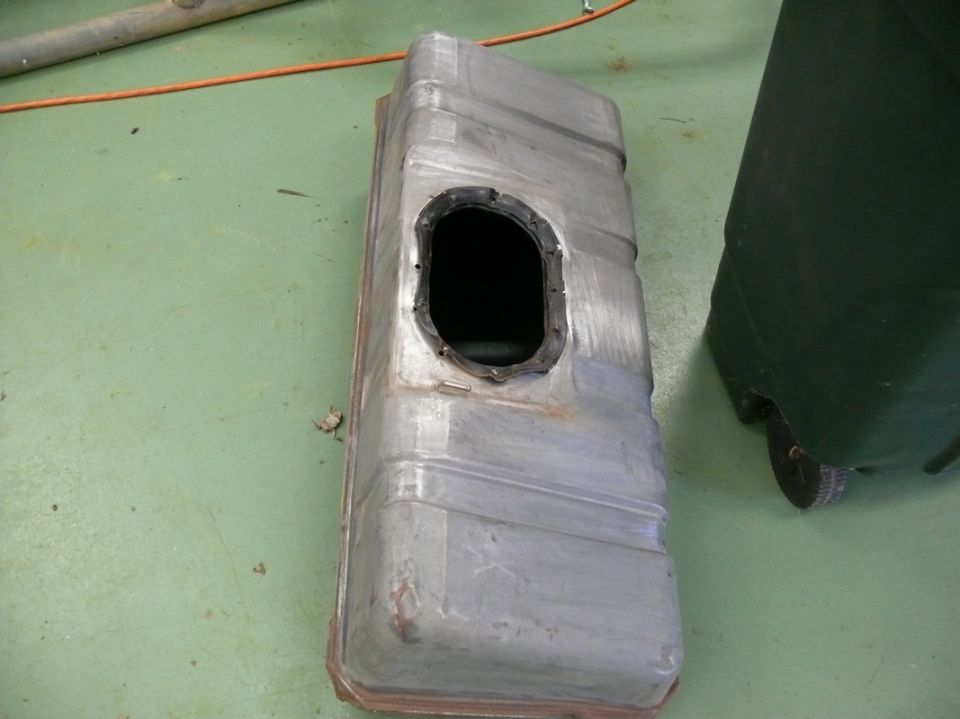Metal fuel tank with a black gasket around an oval opening
