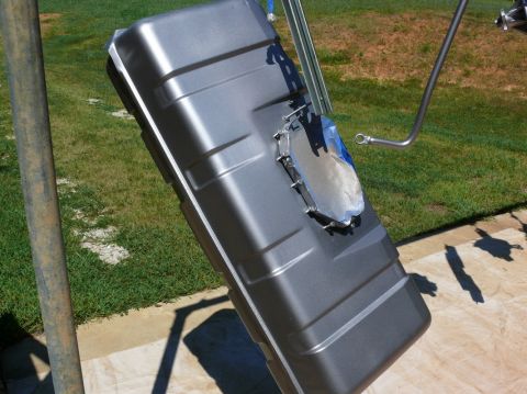 1976 Chevrolet Corvette - A gray metal fuel tank is shown mounted on a stand, with a grassy background and concrete patio.