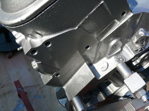 1976 Chevrolet Corvette - Silver-painted engine block with visible bolt holes and some plumbing components.