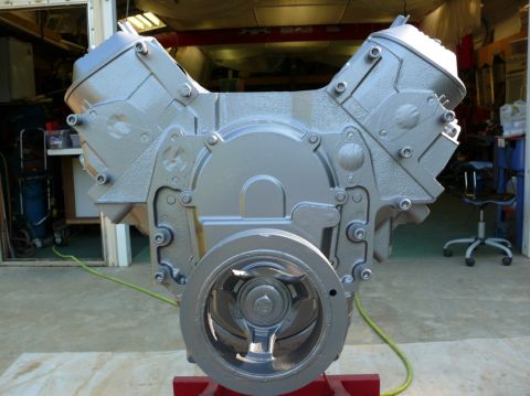 1976 Chevrolet Corvette - A freshly painted V8 engine block is displayed on a stand in a garage setting.