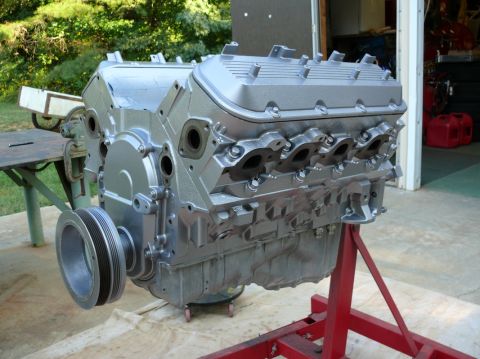 1976 Chevrolet Corvette - A V8 engine, painted silver, is mounted on a red engine stand.
