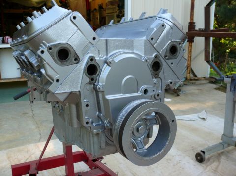 1976 Chevrolet Corvette - A silver engine block is mounted on a red stand, ready for installation or work.