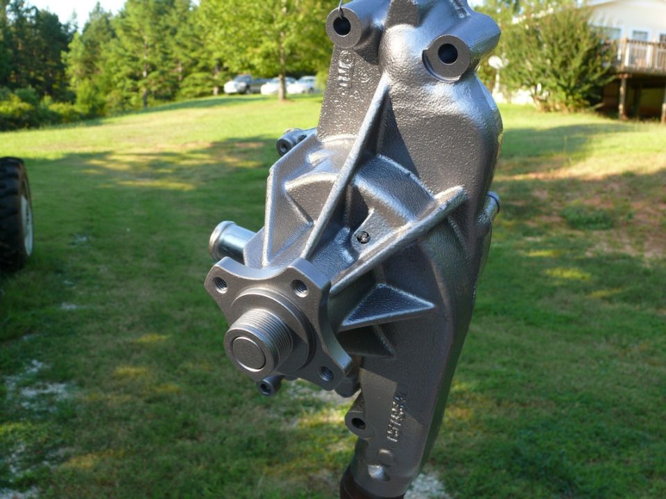 Gray metal water pump with threaded shaft and mounting holes, outdoors