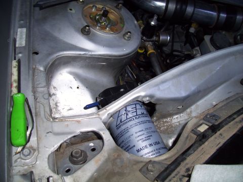 1995 Ford Probe - Close-up view of engine bay components including a fuel filter and a green screwdriver.