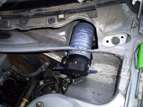 1995 Ford Probe - Close-up view of a fuel filter and pump assembly installed in the engine bay, with visible text indicating 'Made in USA'.