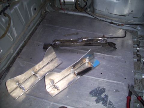 1995 Ford Probe - The interior floor of a car is shown with seat mounting hardware and custom metal brackets.
