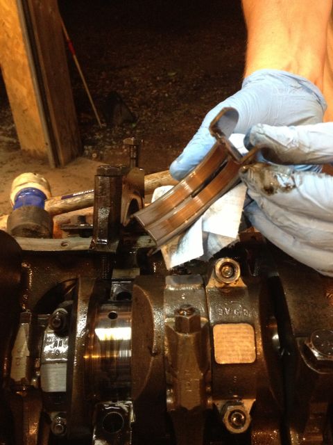 1989 Ford Bronco - Worn engine crankshaft bearings are removed from an engine block.