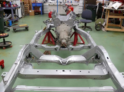 1976 Chevrolet Corvette - The chassis and powertrain of a vehicle are displayed in a workshop setting.