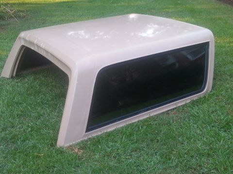 1967 Ford Mustang - Tan truck cap with tinted windows, photographed outdoors on a grassy lawn.