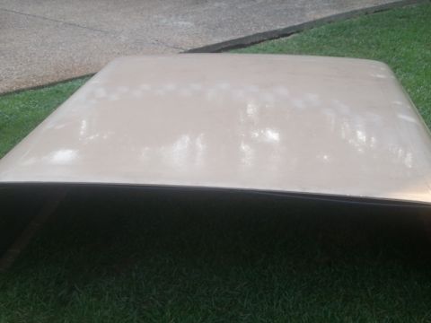 1967 Ford Mustang - A beige car roof with visible wear and tear, photographed outdoors.